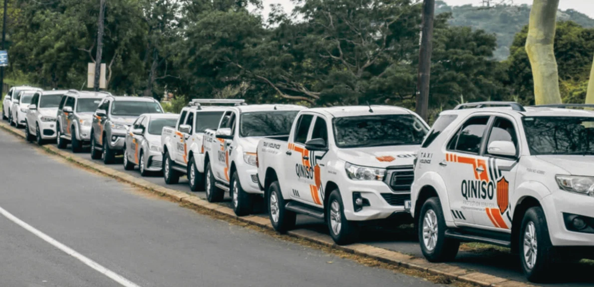 A line of Qiniso Protection Services branded patrol vehicles